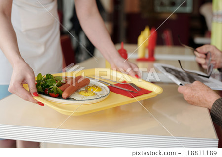 Serving Breakfast Plate Containing Sausages and Fried Eggs Serving Breakfast Plate Containing Sausages and Fried Eggs 118811189