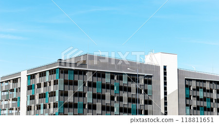 Urban residential building, tall multistory apartment block. Outdoor city structure with blue sky, 118811651