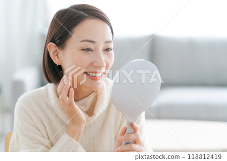 一個照鏡子做皮膚護理的女人 118812419