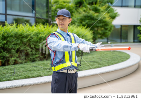 一名男警衛用導桿引導交通 118812961