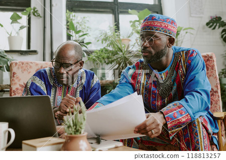African American male workers sitting in coworking zone and looking at screen, they reading content of new project African American male workers sitting in coworking zone and looking at screen, they reading content of new project 118813257