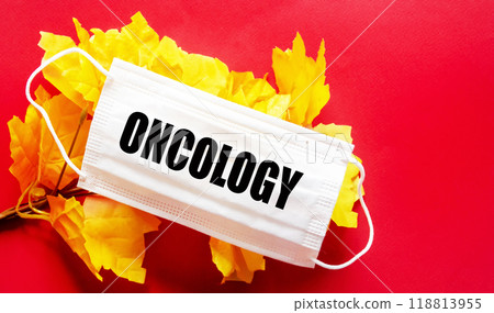 On a red background there is a medical mask with the text ONCOLOGY. Medical concept 118813955