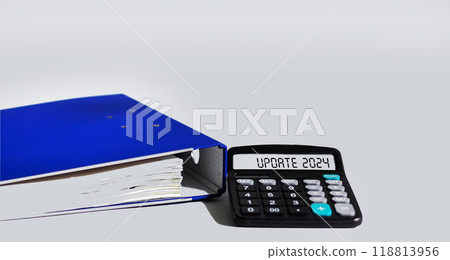 Calculator with UPDATE 2024 on the display, next to a blue folder on a white background.  118813956