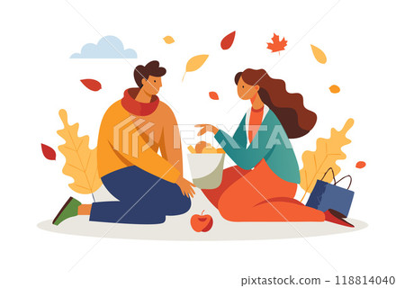 Couple enjoying an autumn picnic with falling leaves and warm clothes 118814040