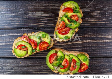 Avocado toast topped with tomato and green onion on a slice of carrot bread 118814721