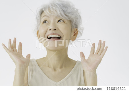 A senior woman with white hair and a surprised face 118814821