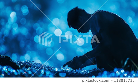 Silhouette of a man inspecting sparkling objects at night Silhouette of a man inspecting sparkling objects at night 118815733