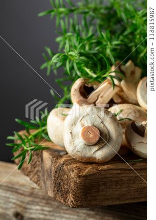 White champignons with rosemary on a wooden board. 118815987