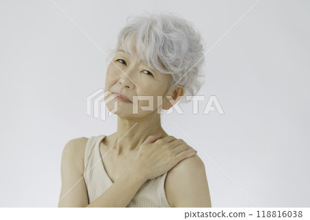 Gray-haired senior woman holding her shoulders, stiff shoulders 118816038