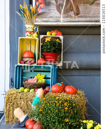 Halloween decorations. Decorated entrance of a house on the street. Pumpkins, flowers, spikelets, boxes as decorations Halloween decorations. Decorated entrance of a house on the street. Pumpkins, flowers, spikelets, boxes as decorations 118816513