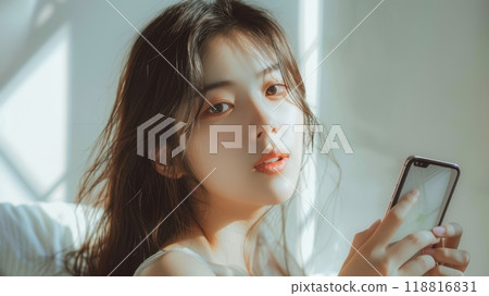 Happy smiling pretty asian woman holding mobile phone looking camera Generative AI 118816831