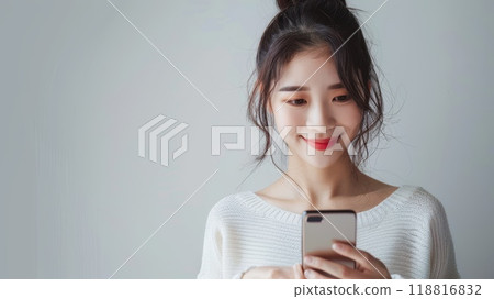 Happy smiling pretty asian woman holding mobile phone looking camera Generative AI 118816832