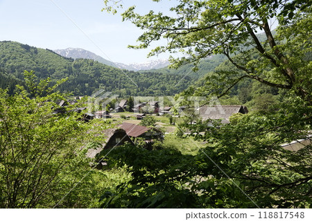 Shirakawa-go scenery seen from a small hill: Snow-covered mountains and a village of old Gassho-style houses 118817548
