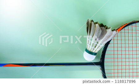 White badminton shuttlecocks and badminton rackets on green background concept of badminton lovers and competition. White badminton shuttlecocks and badminton rackets on green background concept of badminton lovers and competition. 118817896