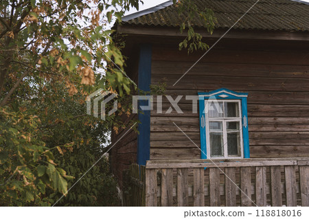 Rustic house with blue windows in the evening in the village Rustic house with blue windows in the evening in the village 118818016