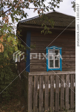 Rustic house with blue windows in the evening in the village 118818017