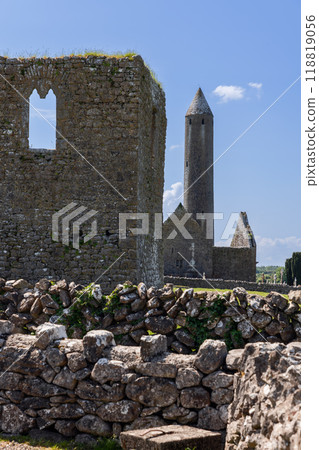 Round tower of Kilmacduagh Abbey framed by ruins and stone walls 118819056