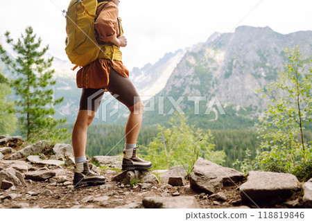 Hiking boot. Close-up of female legs in hiking boots on hiking trail, on top of mountain outdoors. 118819846