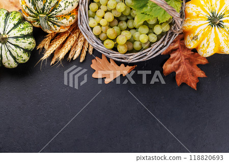 Autumn-themed food arrangement with pumpkins, pears, grapes, and autumn leaves 118820693