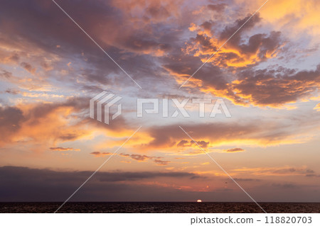 A dramatic and moody sunset sky filled with dark, swirling clouds A dramatic and moody sunset sky filled with dark, swirling clouds 118820703