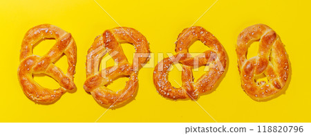 Pretzels scattered across a bright yellow background 118820796