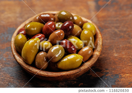 An assortment of various olives presented in a bowl, showcasing different colors, textures, and flavors 118820830