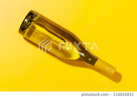 A white wine bottle placed flat on a yellow background A white wine bottle placed flat on a yellow background 118820852