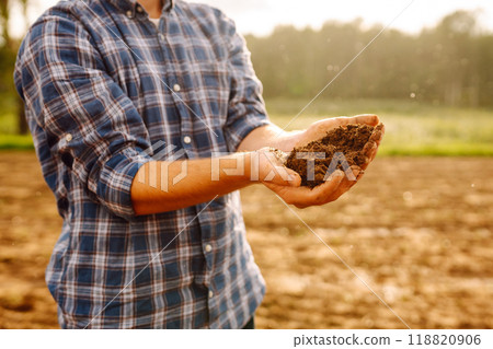 Close-up of a farmer's strong hands on a black field. Concept of gardening, ecology. 118820906