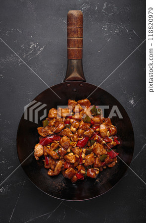 Traditional Chinese dish kung pao chicken in wok pan on dark background top view Traditional Chinese dish kung pao chicken in wok pan on dark background top view 118820979