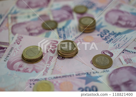 Piles of golden coins placed on Turkish lira banknotes indicating concept of volatile currency with high inflation rate due to inner monetary policy decisions 118821400