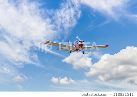 Single engine ultralight plane flying in the blue sky with white clouds Single engine ultralight plane flying in the blue sky with white clouds 118821511