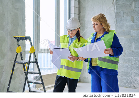 Two female industrial workers at construction site discussing work 118821824