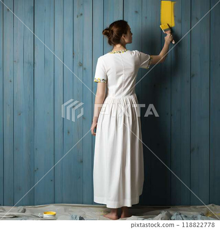 A woman applying yellow paint to a blue wooden wall 118822778
