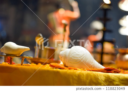 Side view of white horns of Aarti ceremony with priest in background at Ganges 118823049