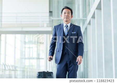 Middle-aged businessman traveling with a suitcase Middle-aged businessman traveling with a suitcase 118823423