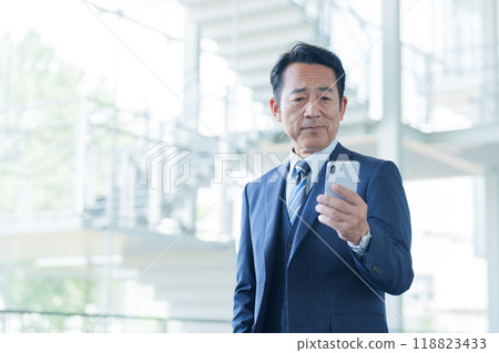 Middle-aged businessman using a smartphone at the airport 118823433