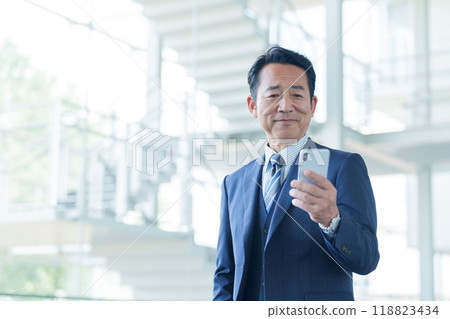 Middle-aged businessman using a smartphone at the airport 118823434