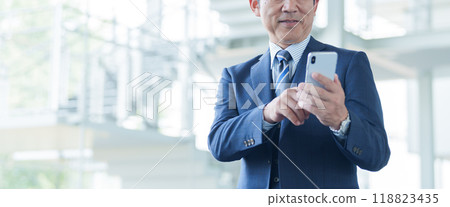 Middle-aged businessman using a smartphone at the airport 118823435