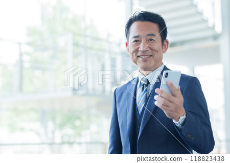 Middle-aged businessman using a smartphone at the airport 118823438