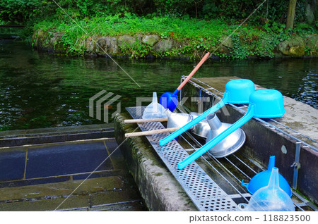 Using a ladle to scoop up natural water 118823500