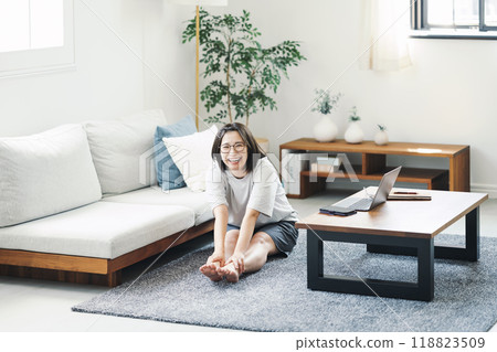 Portrait of a woman stretching in the living room at home 118823509