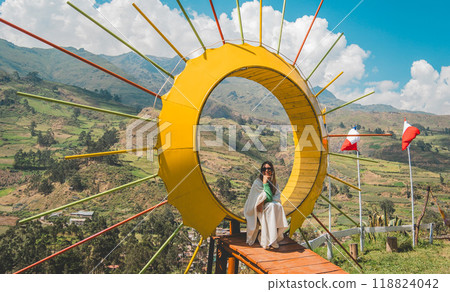 Girl sits in viewpoint yellow circle, traveling through the peruvian andes. Canta. Lima, Peru. 118824042