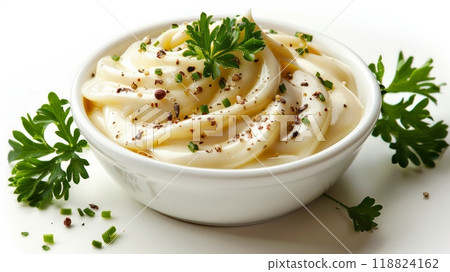 A bowl of creamy white food with parsley garnish on a table, AI 118824162