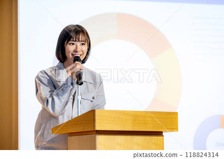 A woman giving a seminar in work clothes. Photo courtesy of Denpa Gakuen, Tokyo Electronics College. 118824314