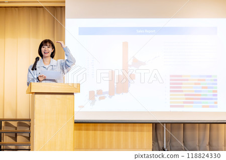 A woman giving a seminar in work clothes. Photo courtesy of Denpa Gakuen, Tokyo Electronics College. 118824330