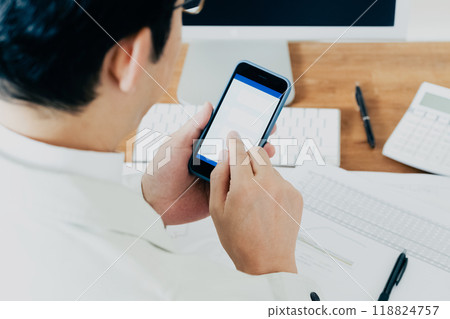 一個穿著工作服的男人操作智慧型手機的手 一個穿著工作服的男人操作智慧型手機的手 118824757