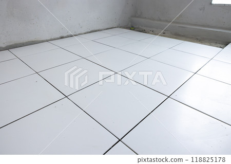 Tile floor under construction in room. Tile floor under construction in room. 118825178