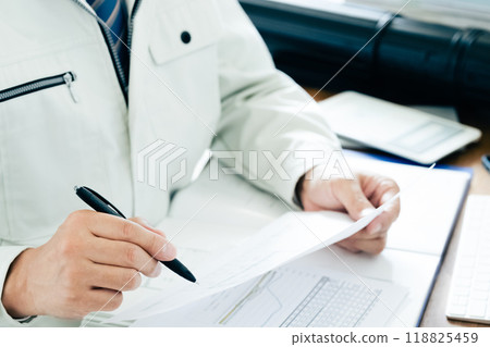 A man in work clothes checking documents 118825459