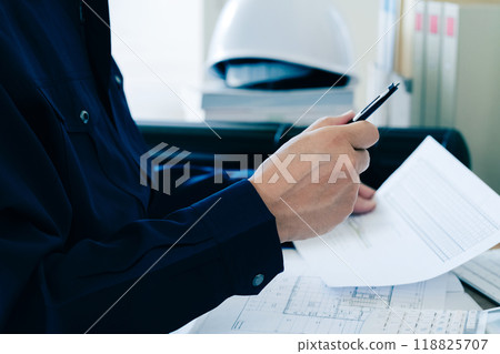 A man in work clothes checking documents A man in work clothes checking documents 118825707