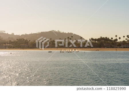 A body of water with a beach and mountains in the background A body of water with a beach and mountains in the background 118825990